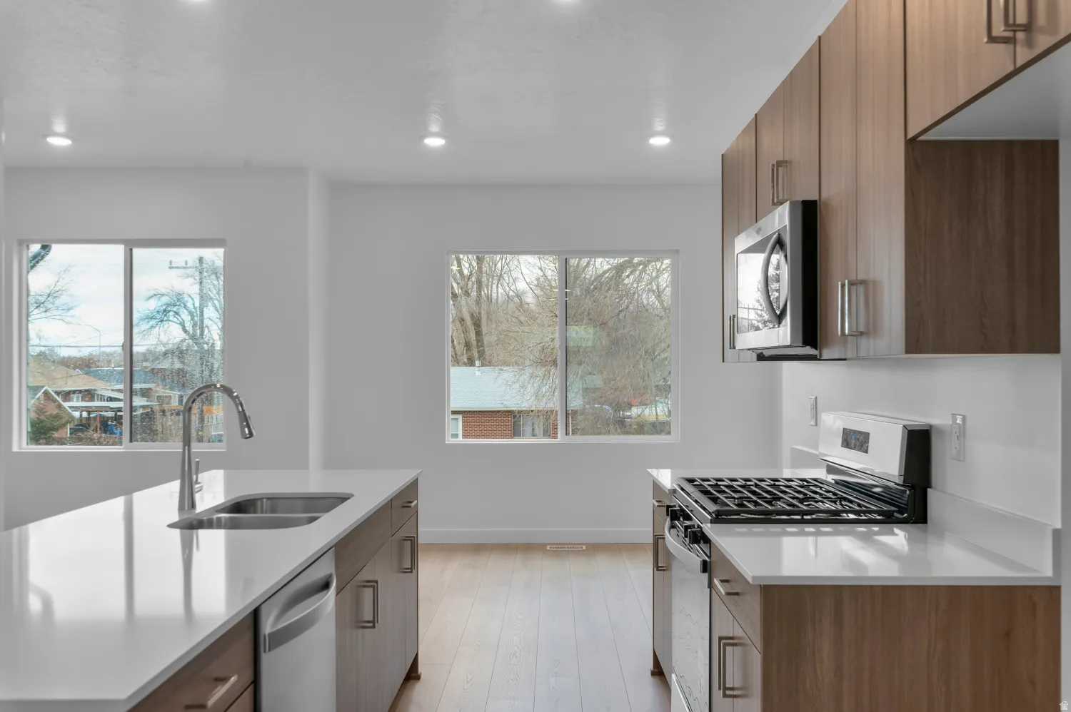 Modern kitchen featuring wood-finish cabinetry and light-toned countertops
