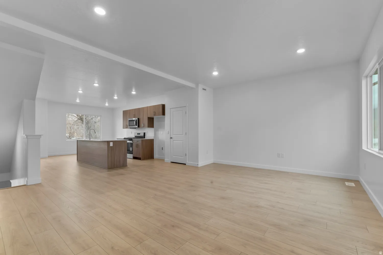 Open-concept living area featuring wood-finish flooring, recessed lighting, and white interior paint