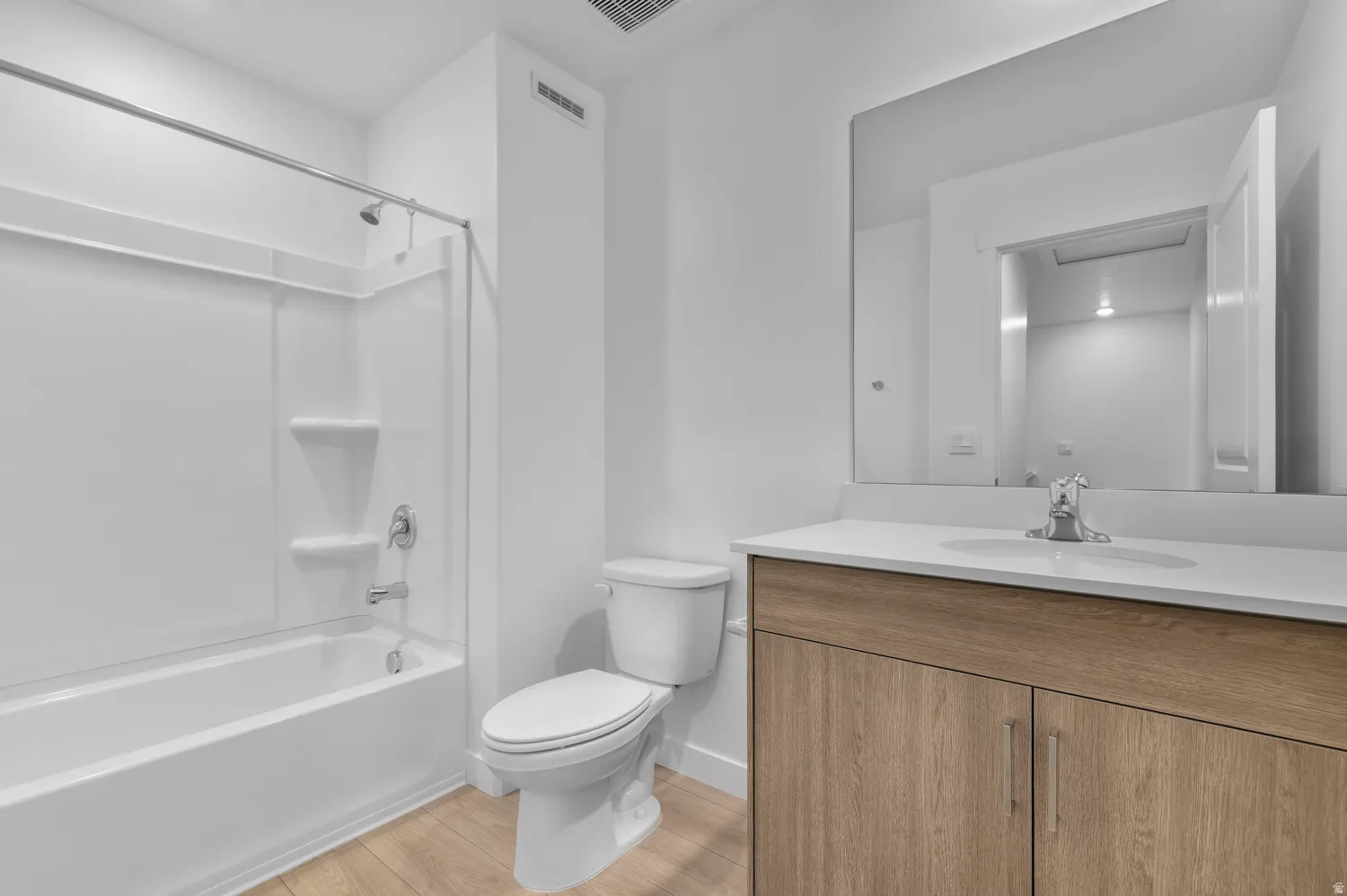 Bathroom featuring a modern vanity with wood-finish cabinetry and a white countertop