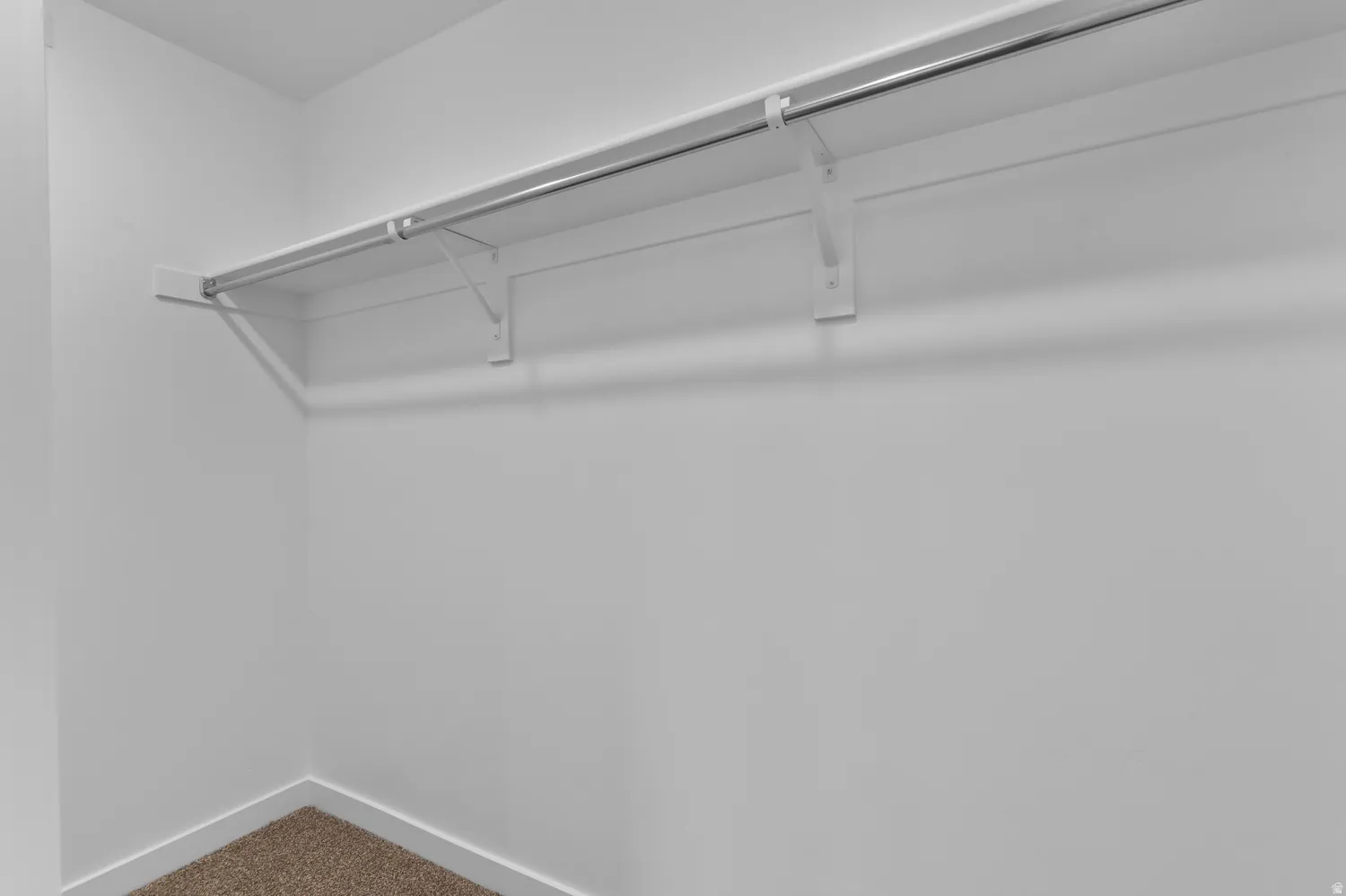 Built-in shelving and hanging rod system featuring white-painted wood and metal construction