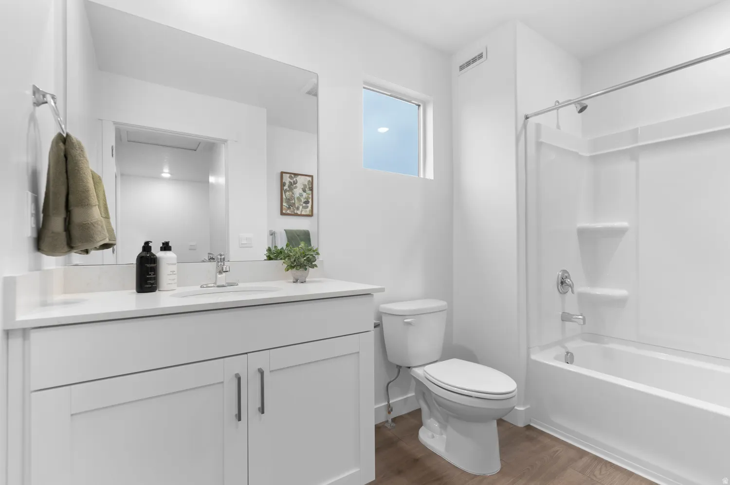 Contemporary bathroom featuring a white vanity with a quartz countertop, an integrated sink, and a large mirror