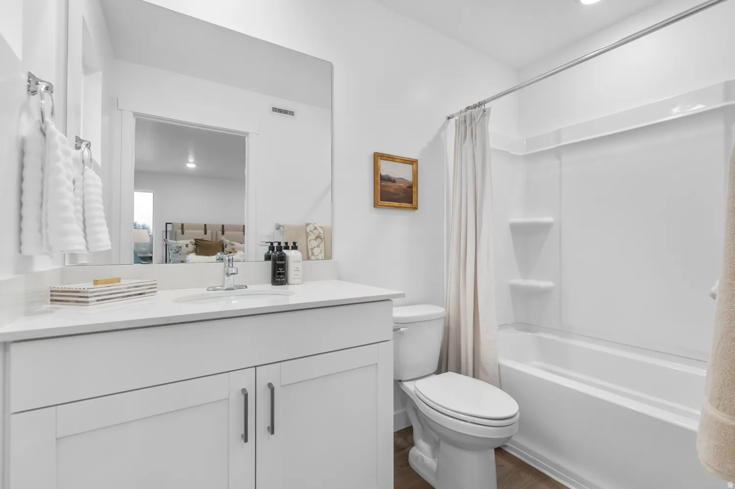 White vanity with a single basin sink, white countertop, and brushed nickel faucet