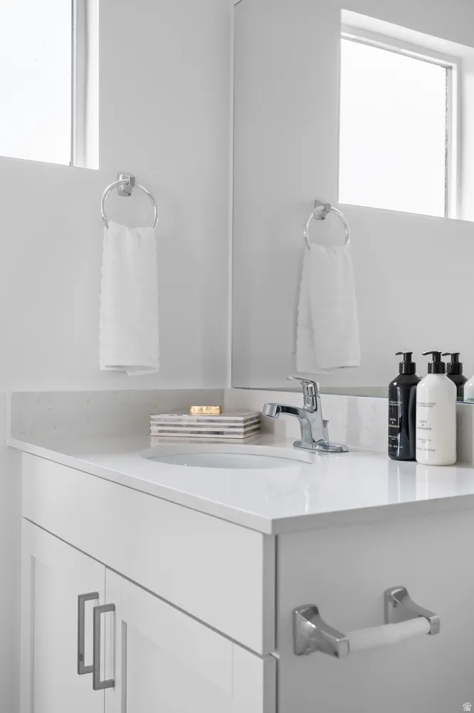 Vanity featuring a white countertop with an integrated sink and chrome faucet