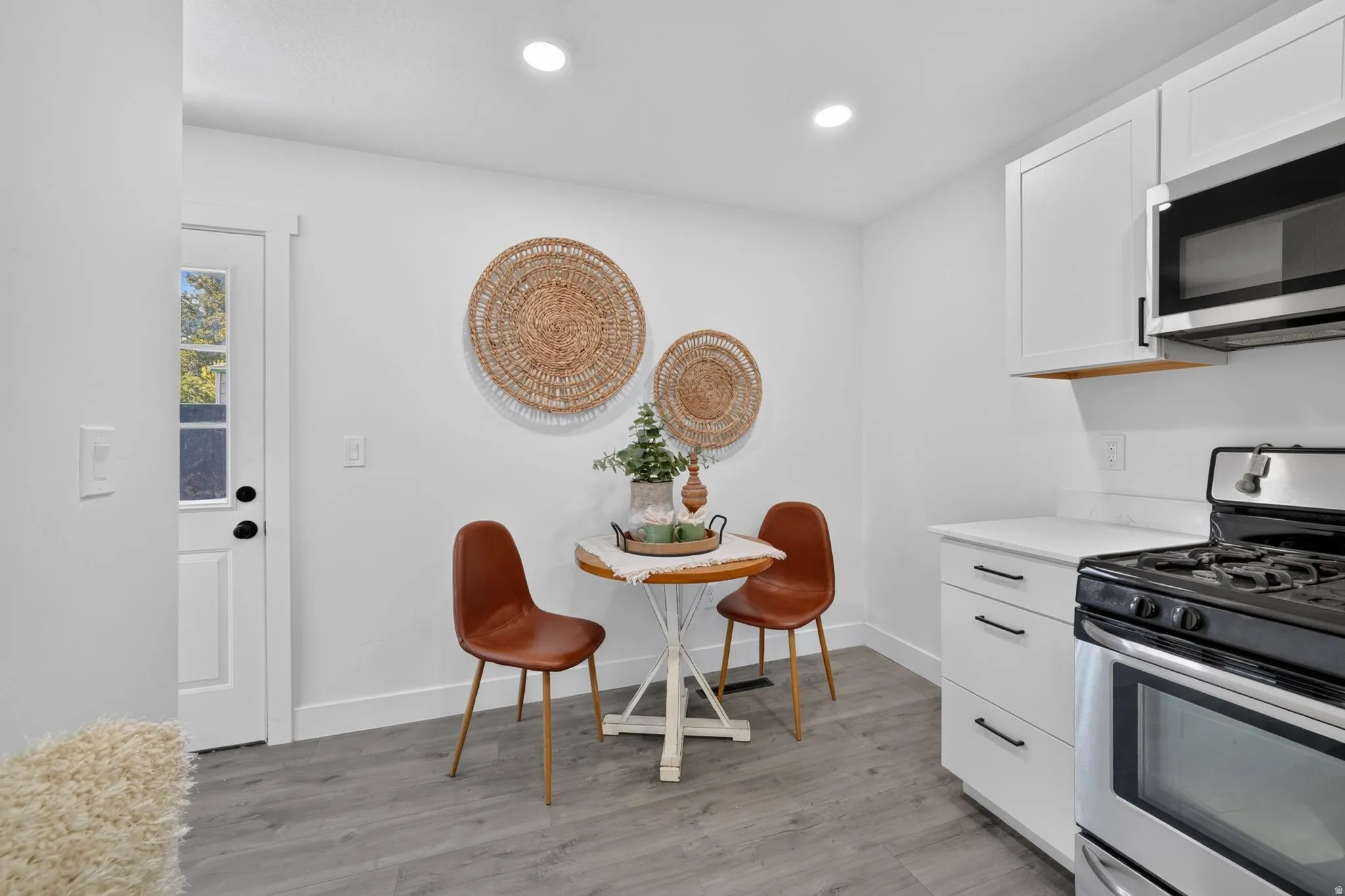 Modern kitchen featuring white cabinetry, a built-in microwave, and a gas range