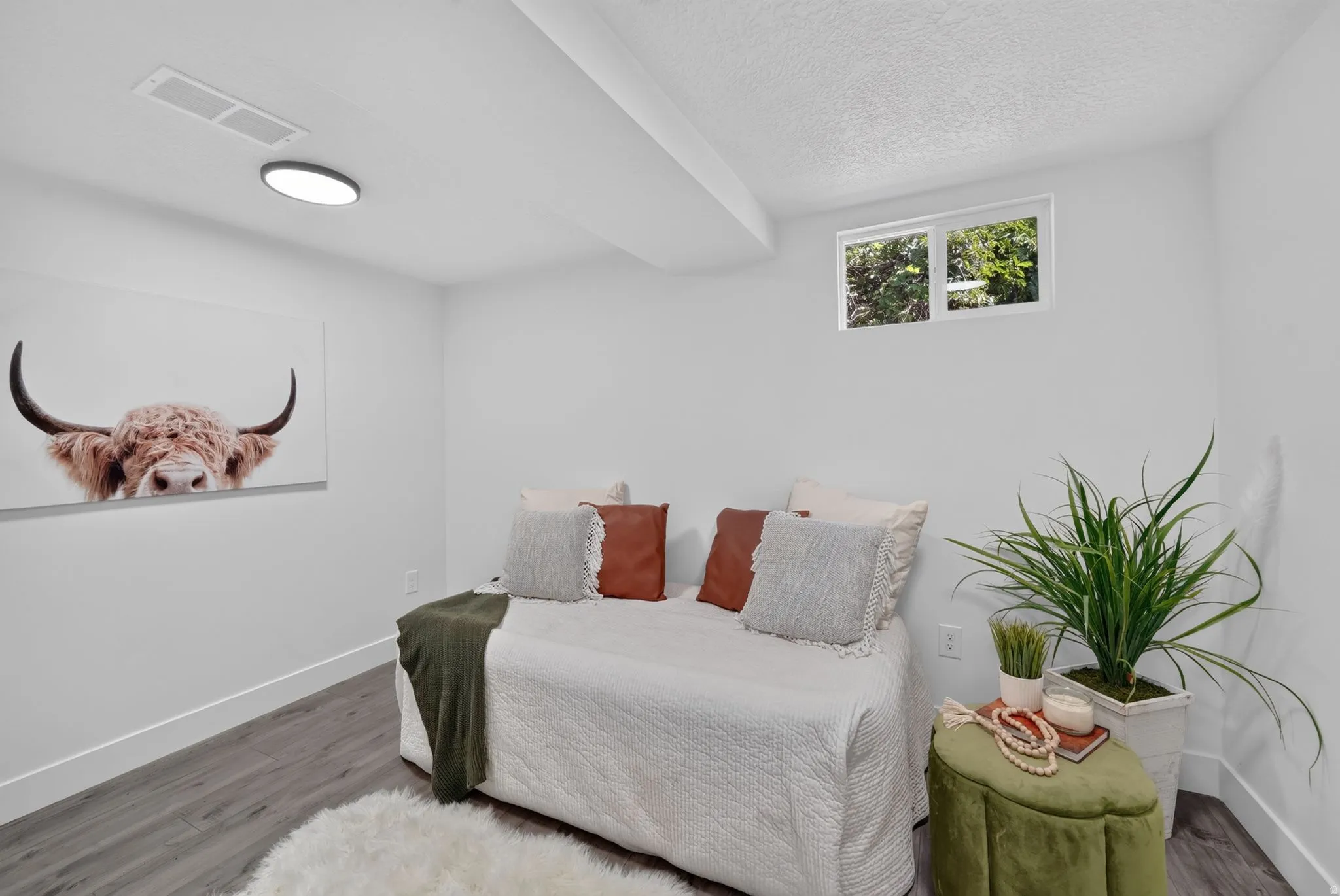 Bright white walls featuring a high window and recessed lighting