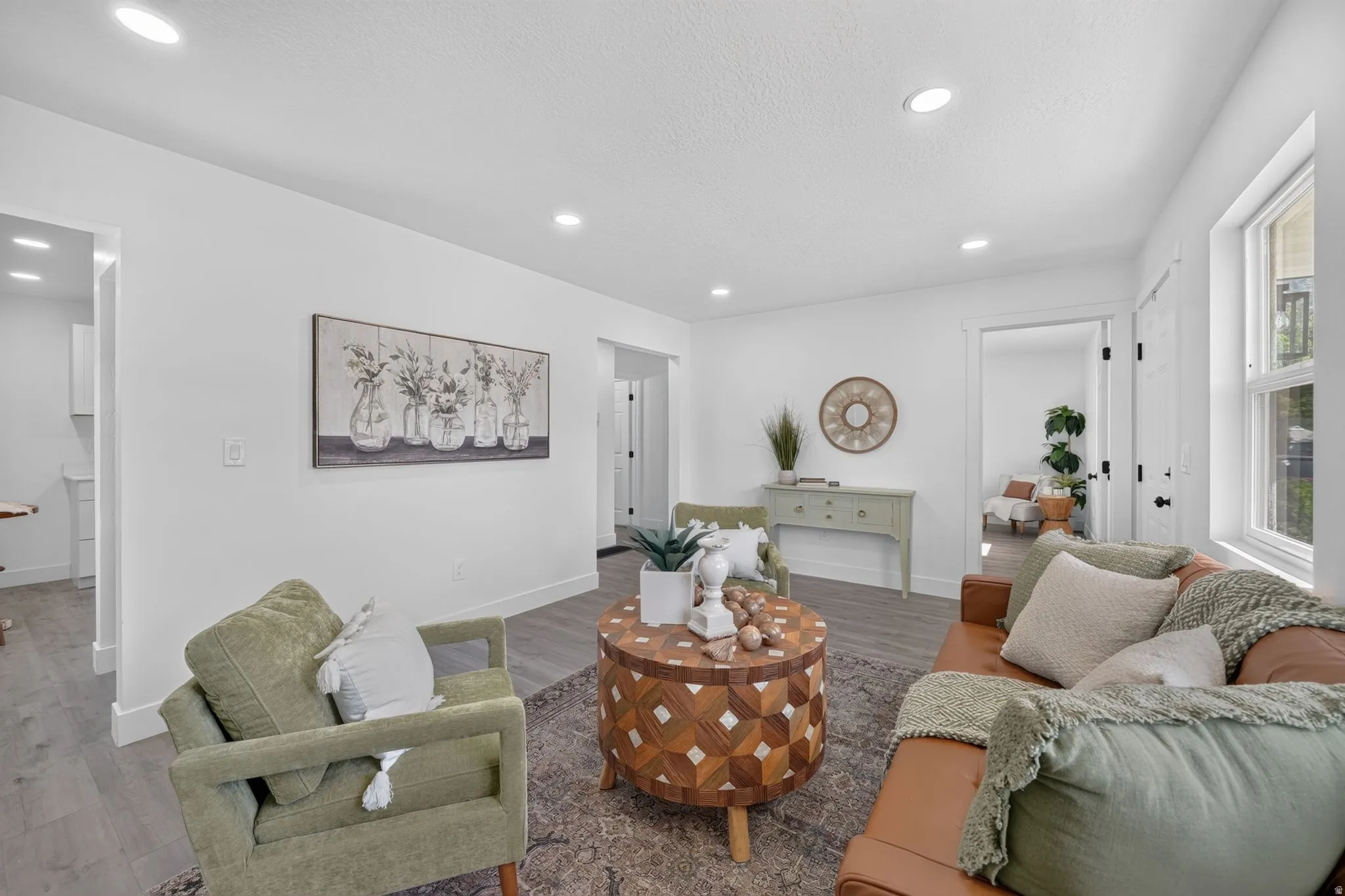 Bright living area with recessed lighting, wood-finish flooring