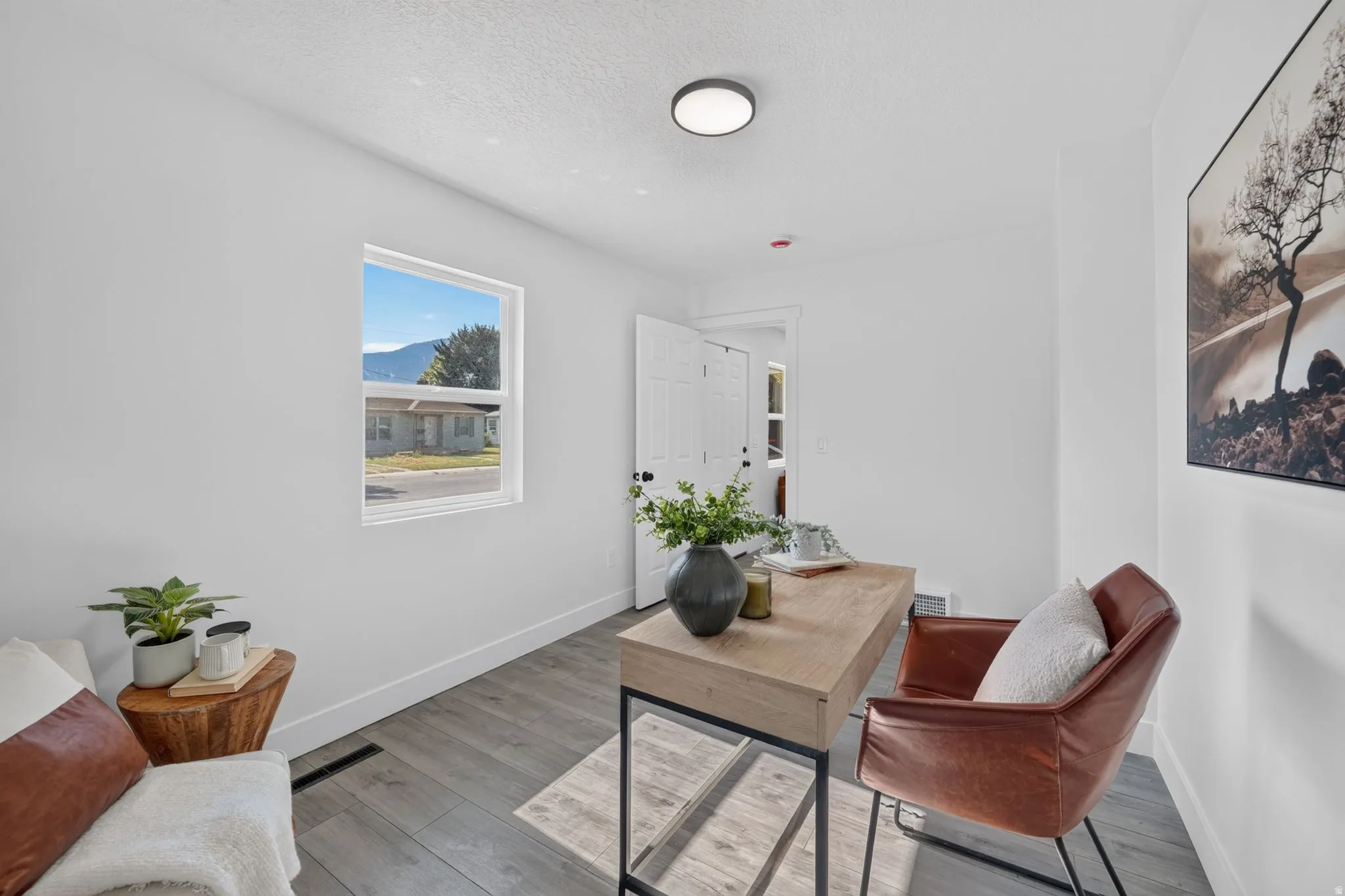 Bright room featuring light grey wood-finish flooring, white walls, and a recessed ceiling light