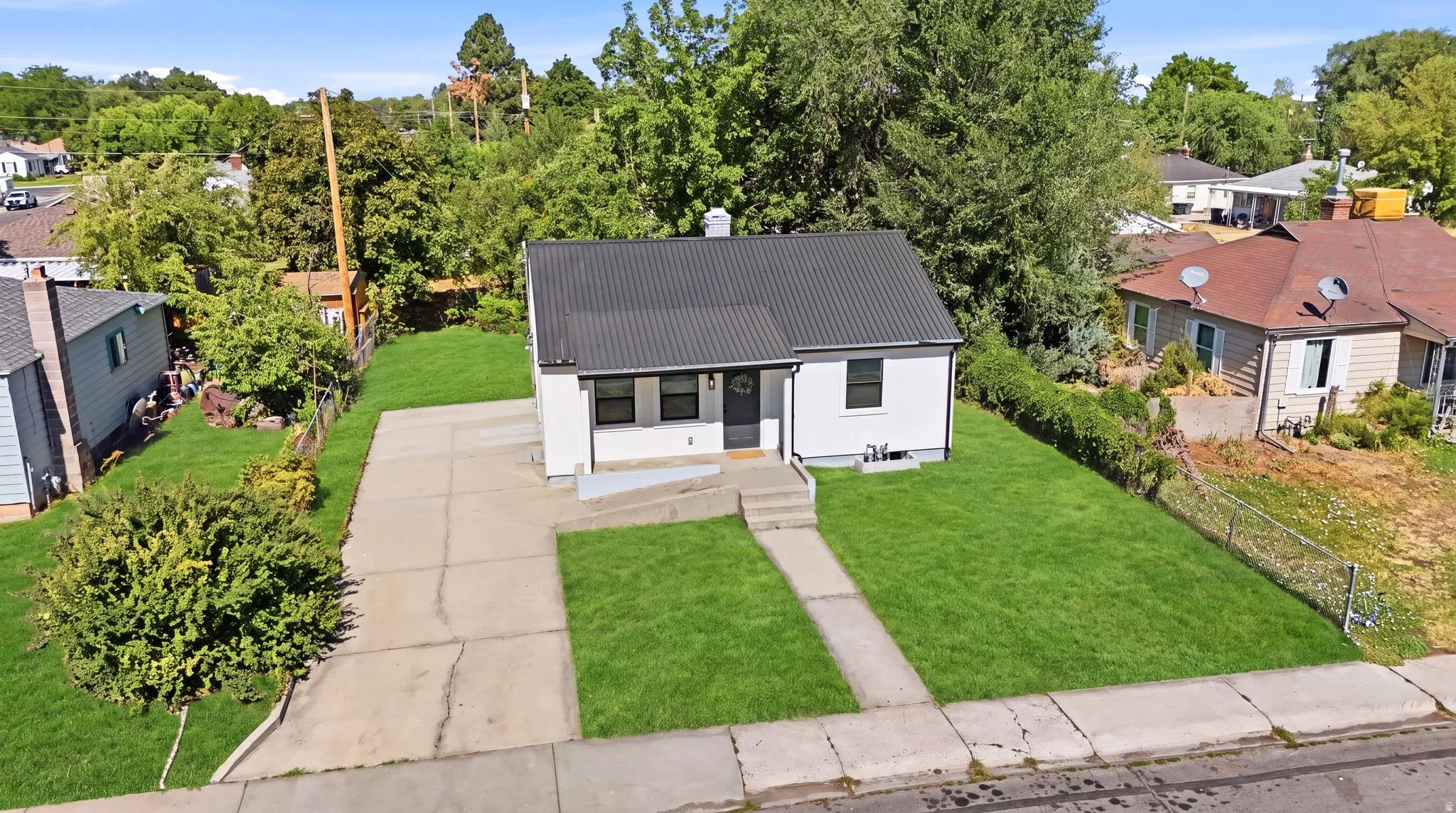 White exterior home with a dark metal roof