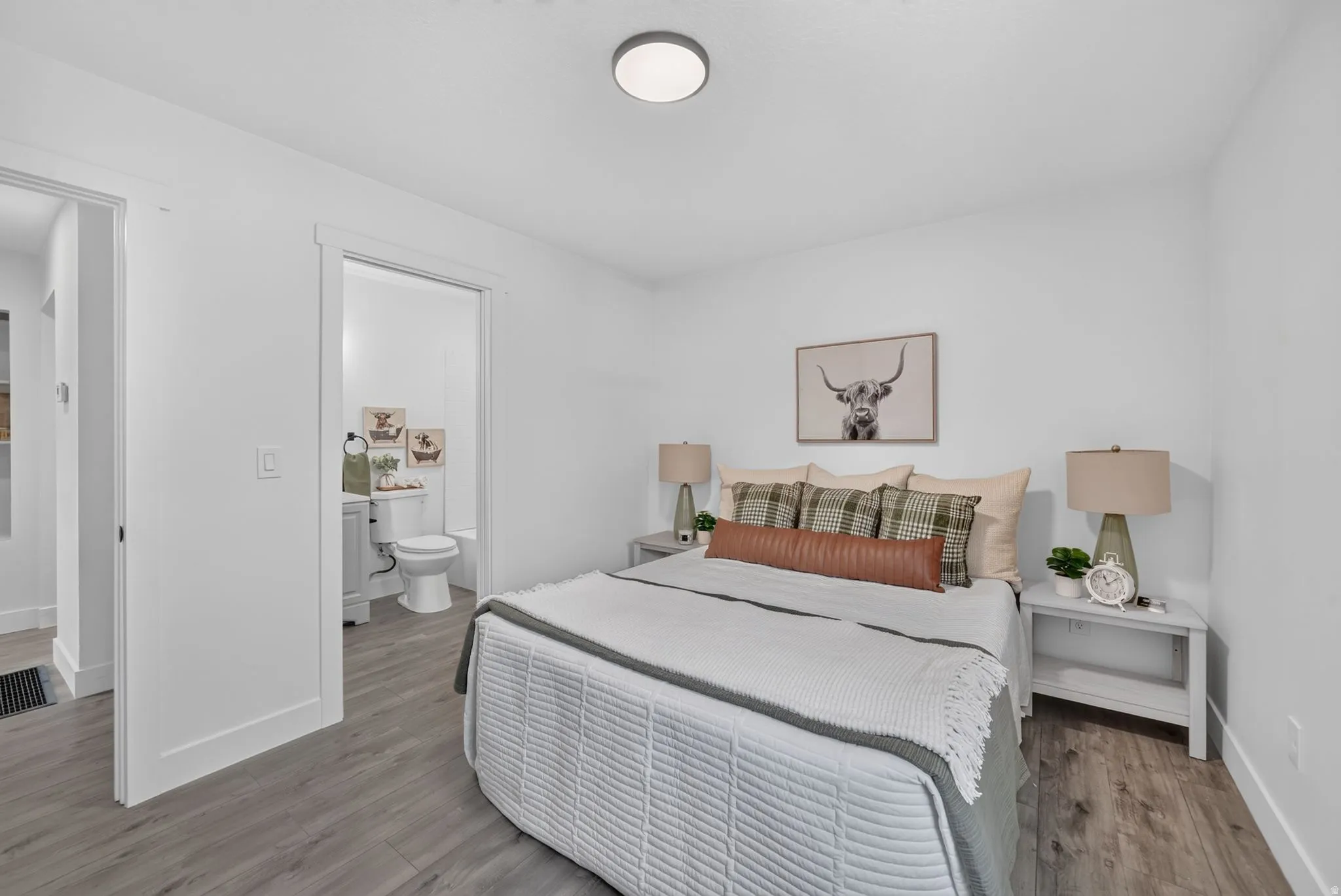 Bedroom featuring wood-finish flooring, white walls, and a recessed ceiling light
