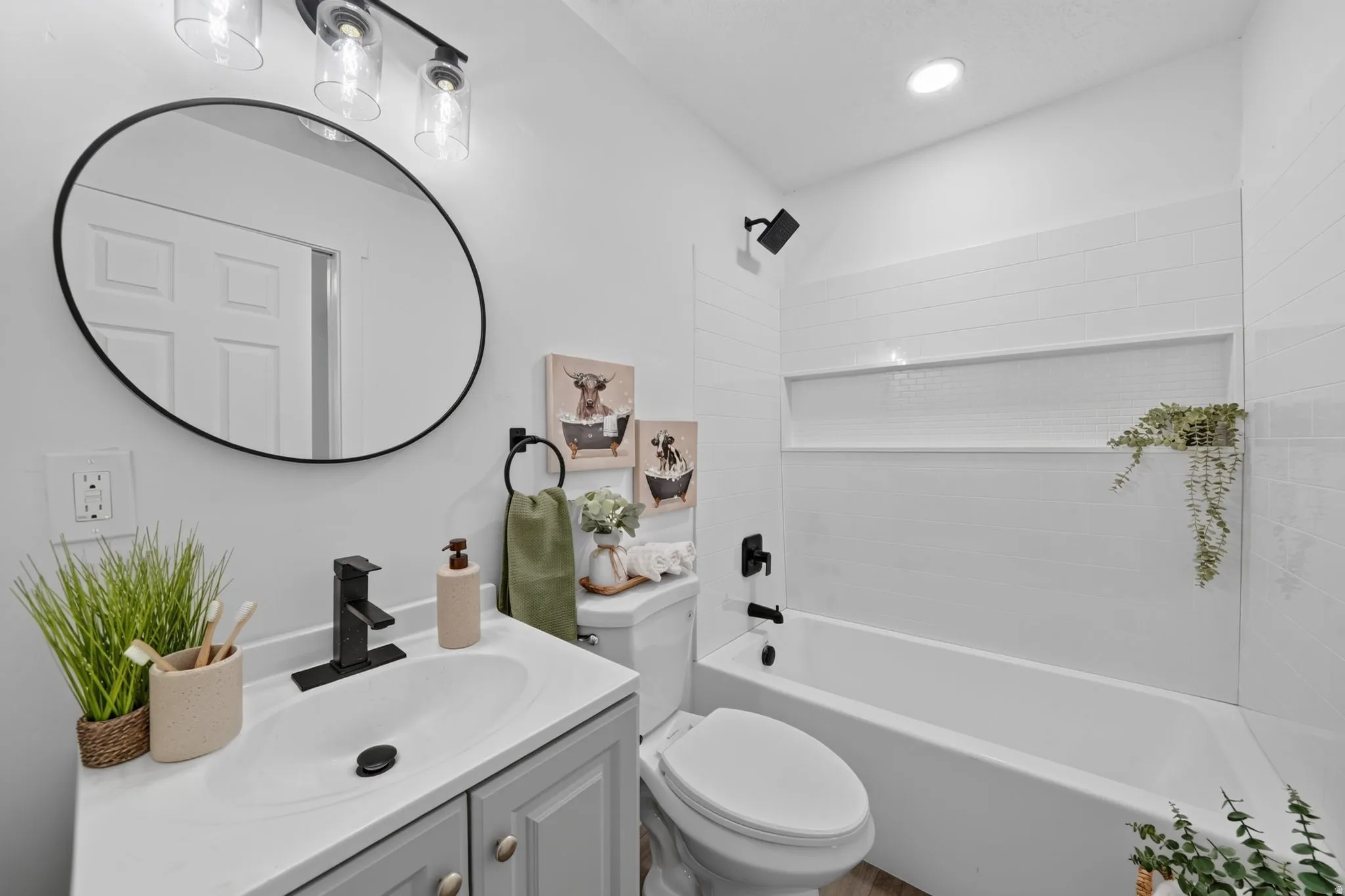 Bathroom featuring a single vanity with a gray cabinet, white countertop, and a black faucet