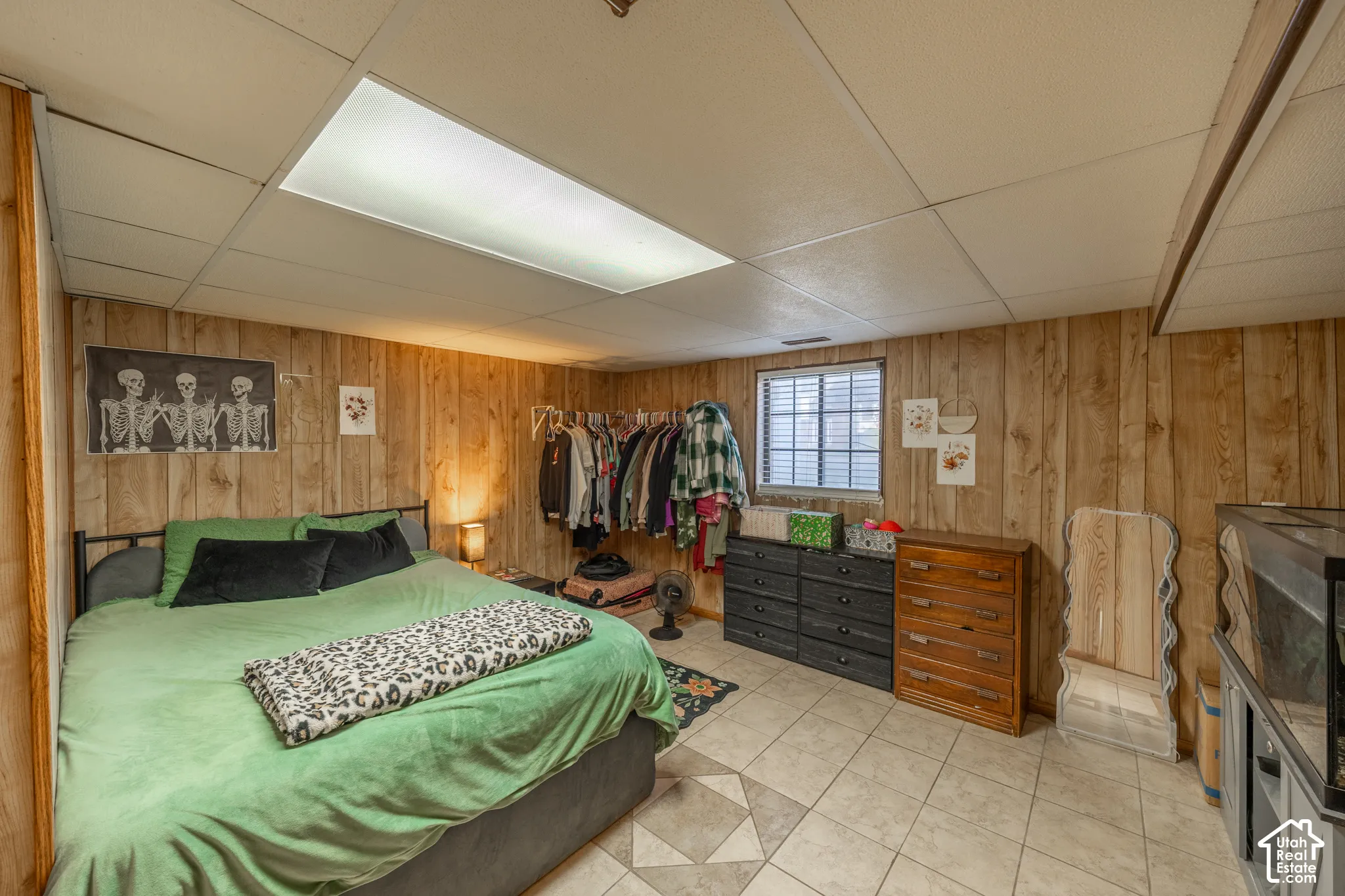 Wood-finish paneled walls, tile flooring, and a drop ceiling with integrated lighting