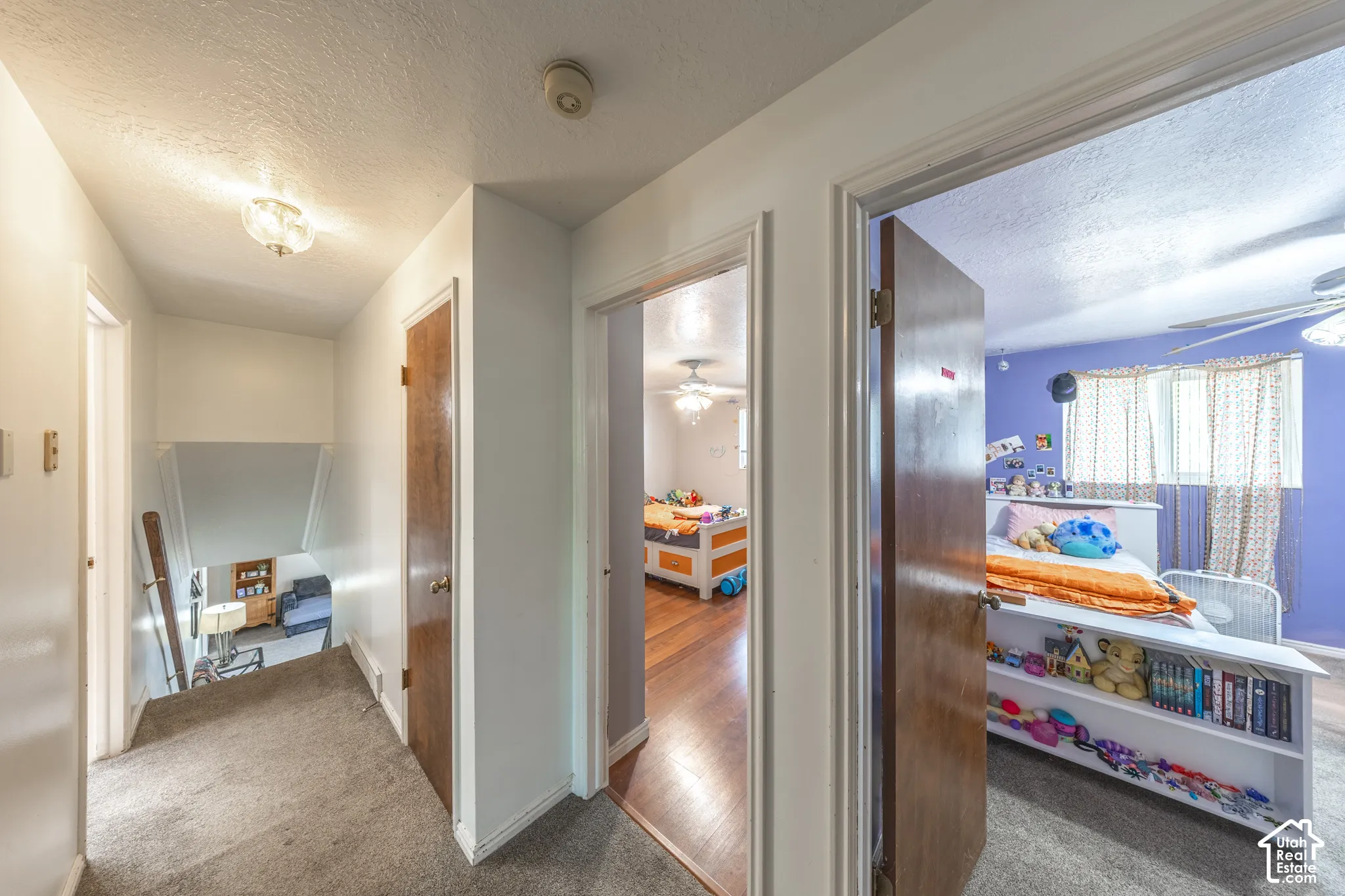 Hallway featuring carpet flooring, white walls, and a ceiling-mounted light fixture