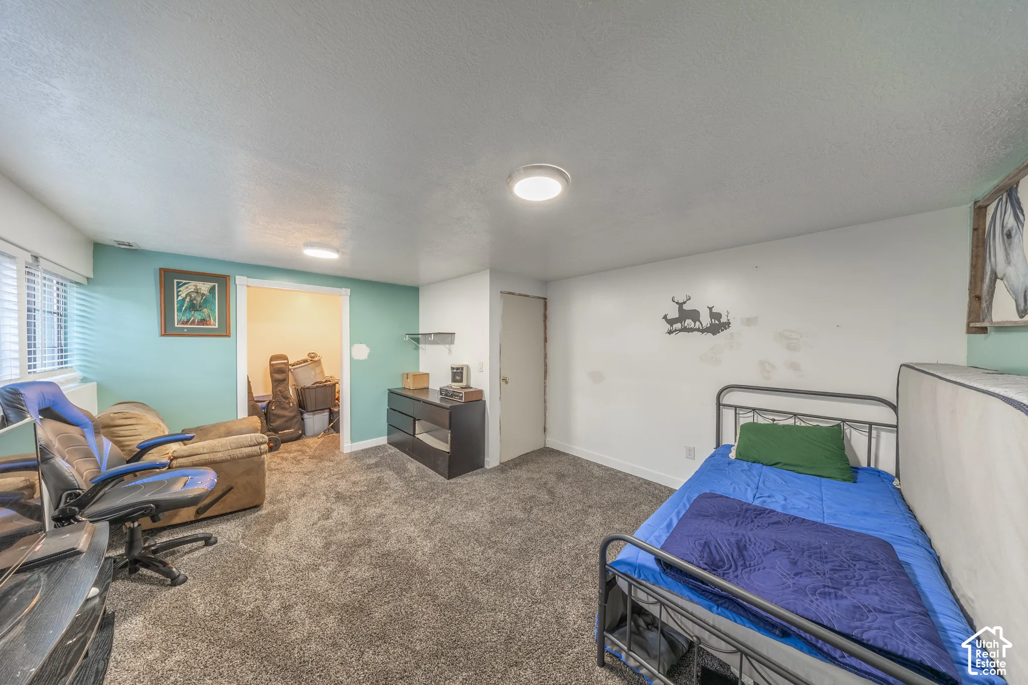 Carpeted room with a recessed entrance, white window blinds, and overhead lighting
