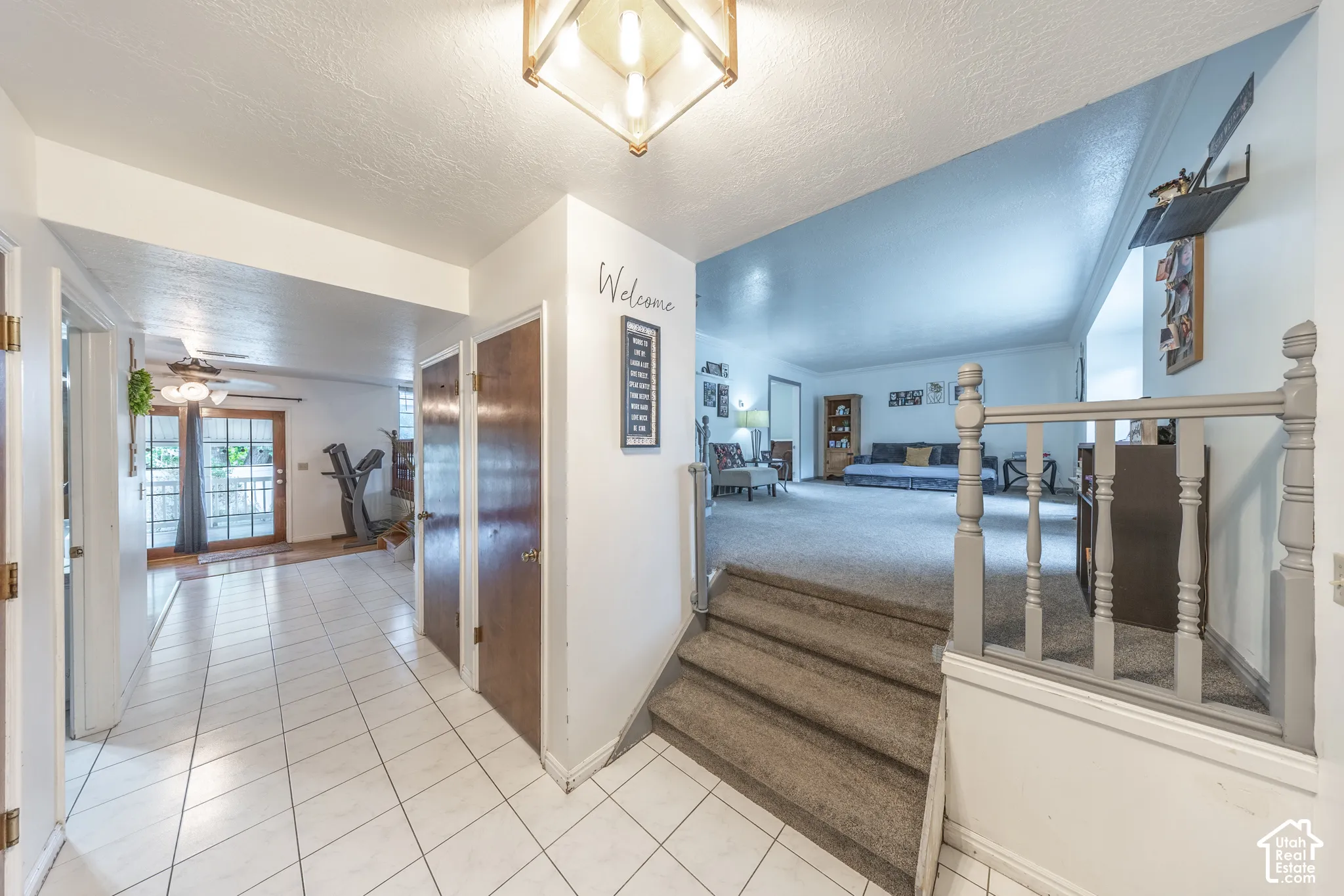 Inviting entry foyer featuring white square tile flooring and a decorative overhead light fixture