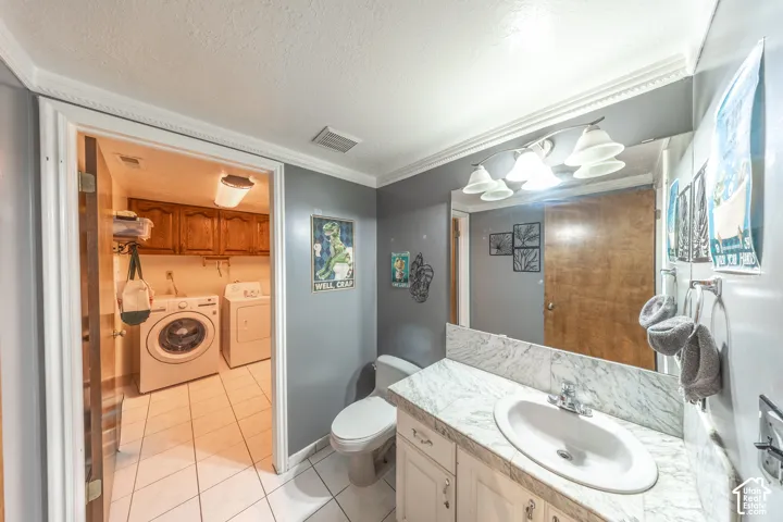Bathroom with a white vanity and a white oval sink set into a white marble-finish countertop