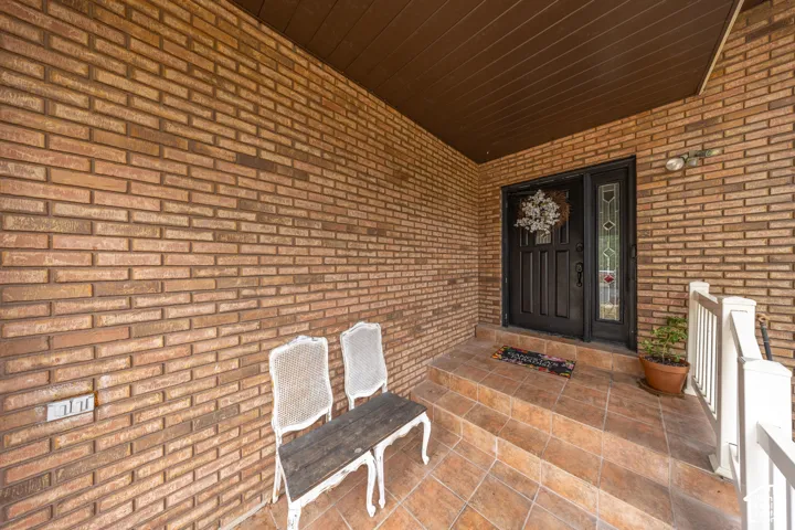 Brick exterior with a dark entry door and sidelight featuring leaded glass detailing
