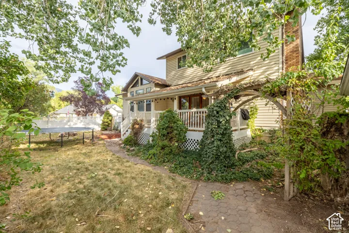 Expansive backyard featuring a partial white fence and established trees