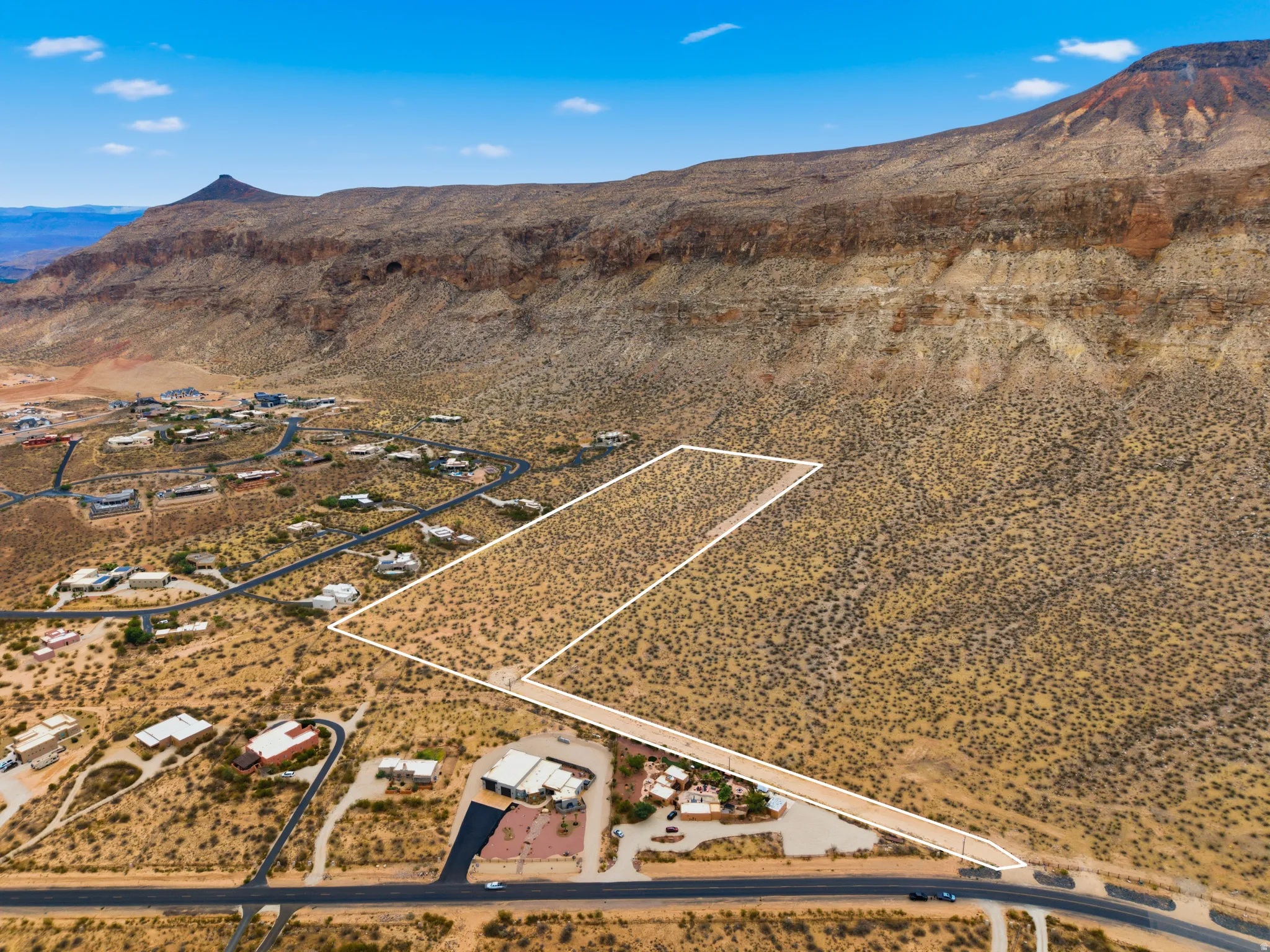 Expansive desert land parcel featuring delineated boundaries, natural arid vegetation, and direct road frontage