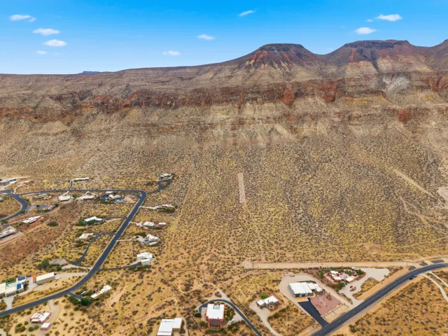 Expansive desert landscape with multiple residences nestled along winding paved roads