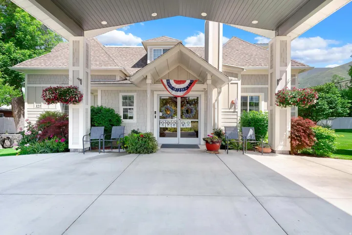 Covered entry porch featuring robust support columns and a concrete drive