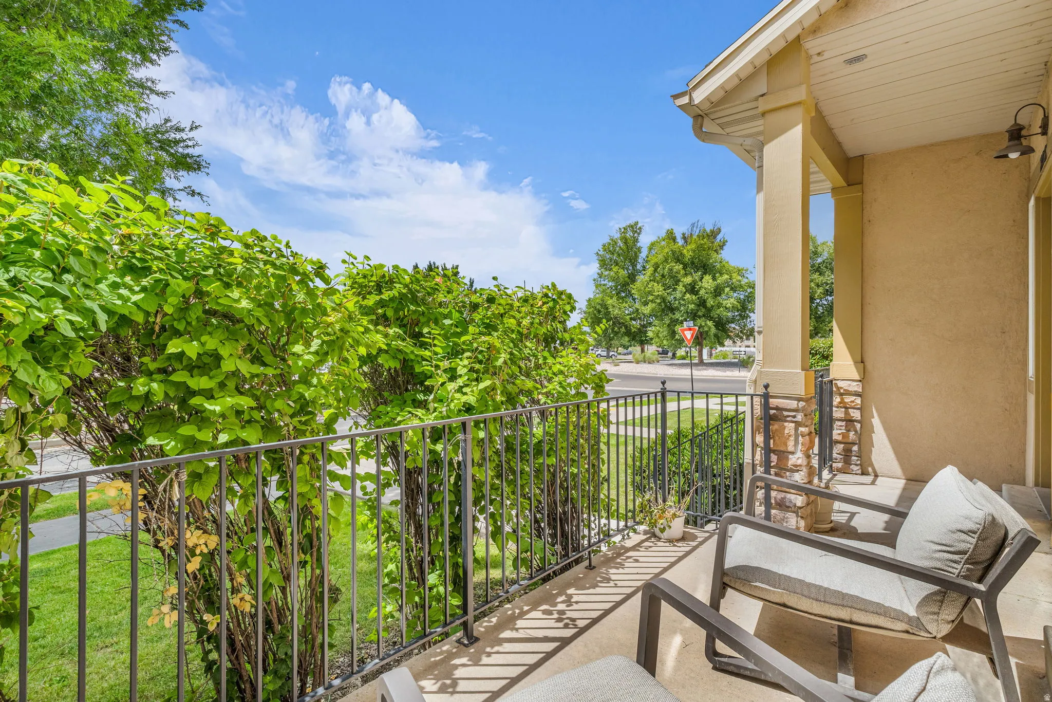 Covered porch featuring stucco siding and stone veneer accents