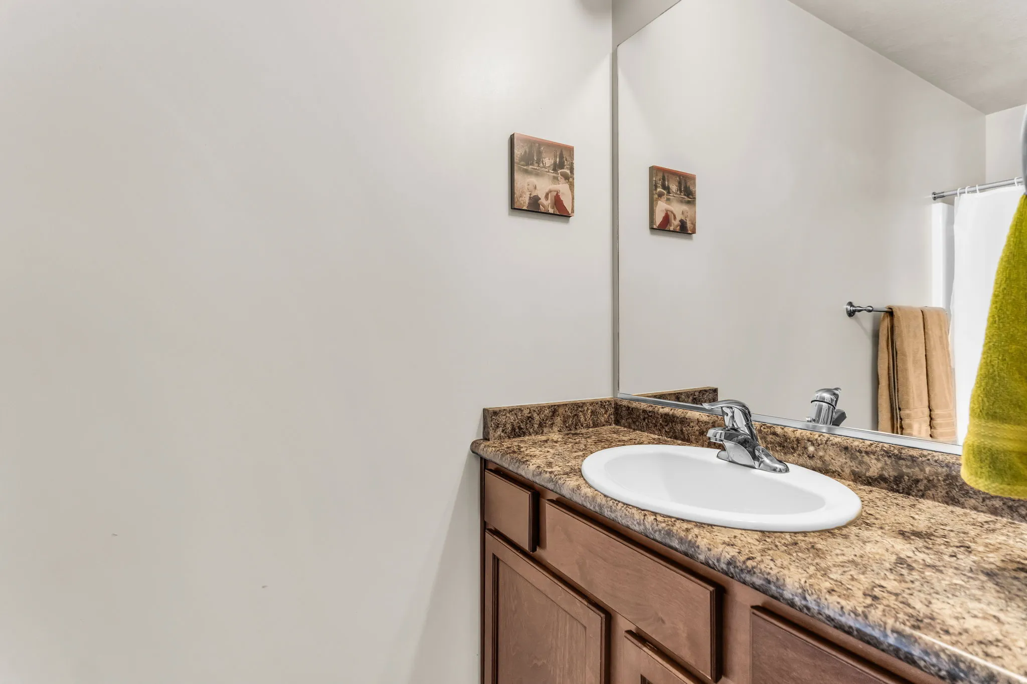 Bathroom vanity featuring an integrated oval sink, chrome faucet, and a speckled countertop