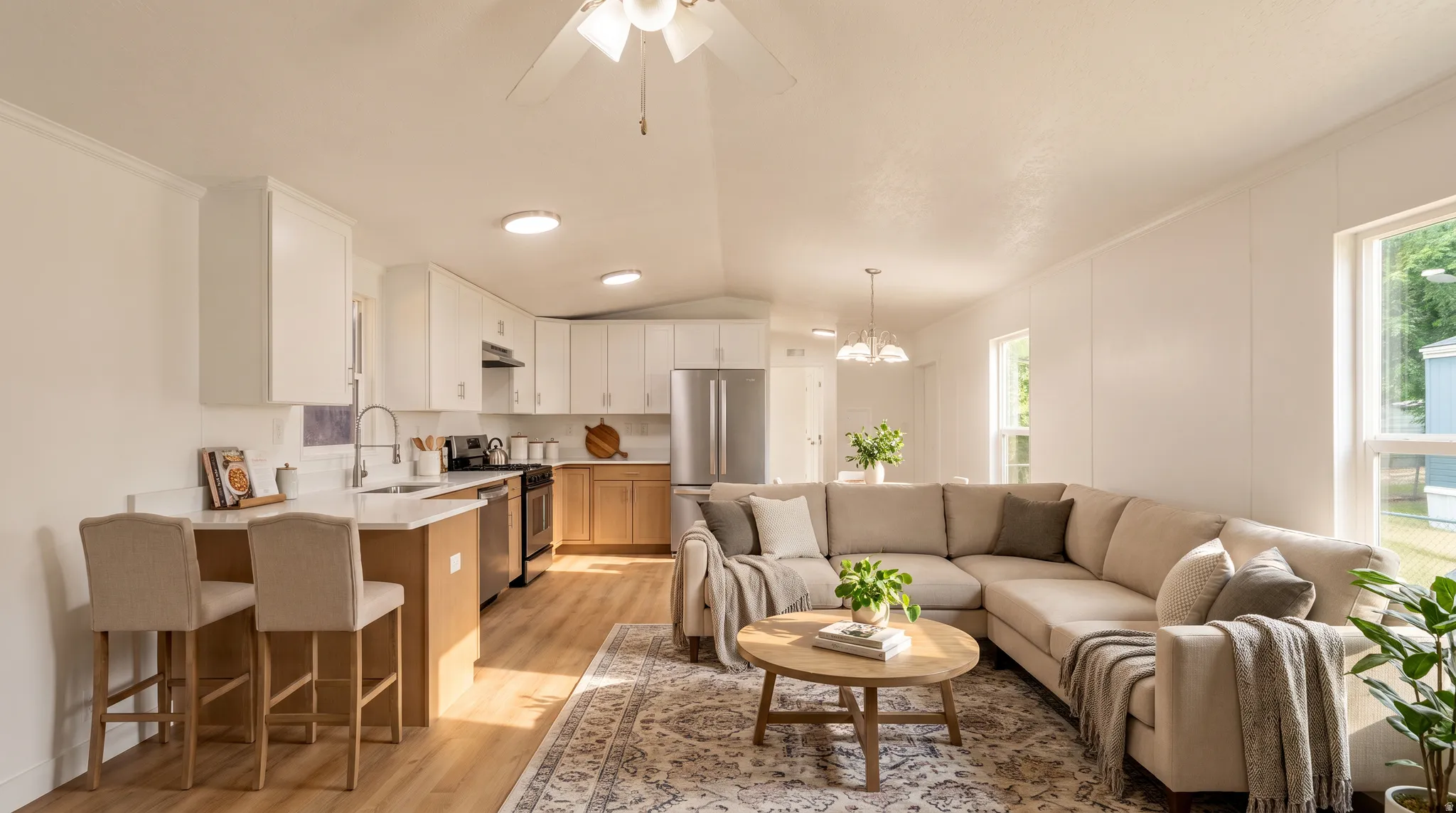 Open concept living space featuring wood-finish flooring, white walls, and multiple windows