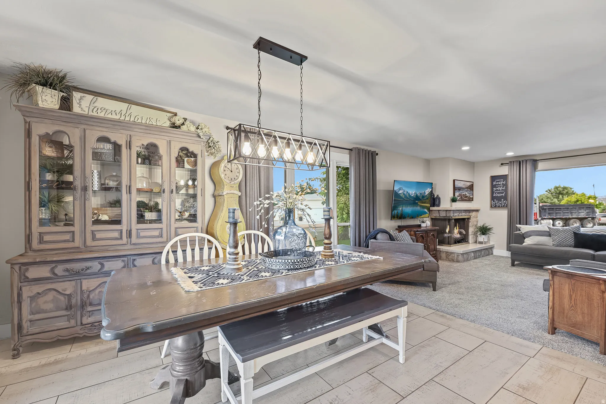 Spacious dining area featuring tile flooring, a linear chandelier, and ample natural light