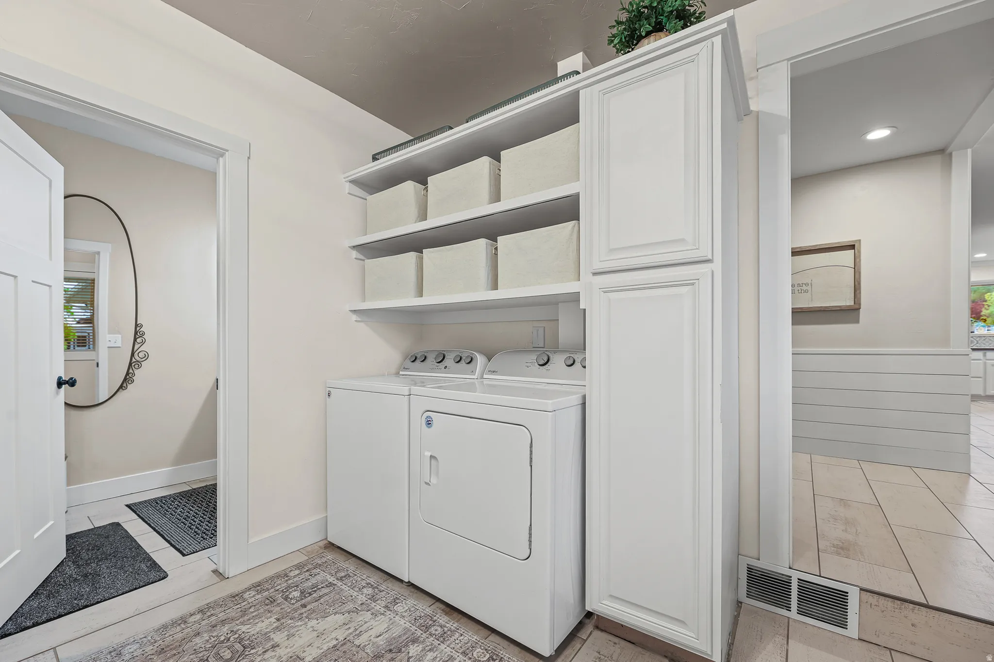 Laundry area featuring white cabinetry, open shelving