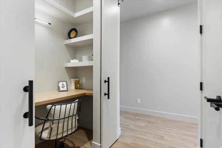 Built-in corner desk with a light wood-finish countertop and floating shelves