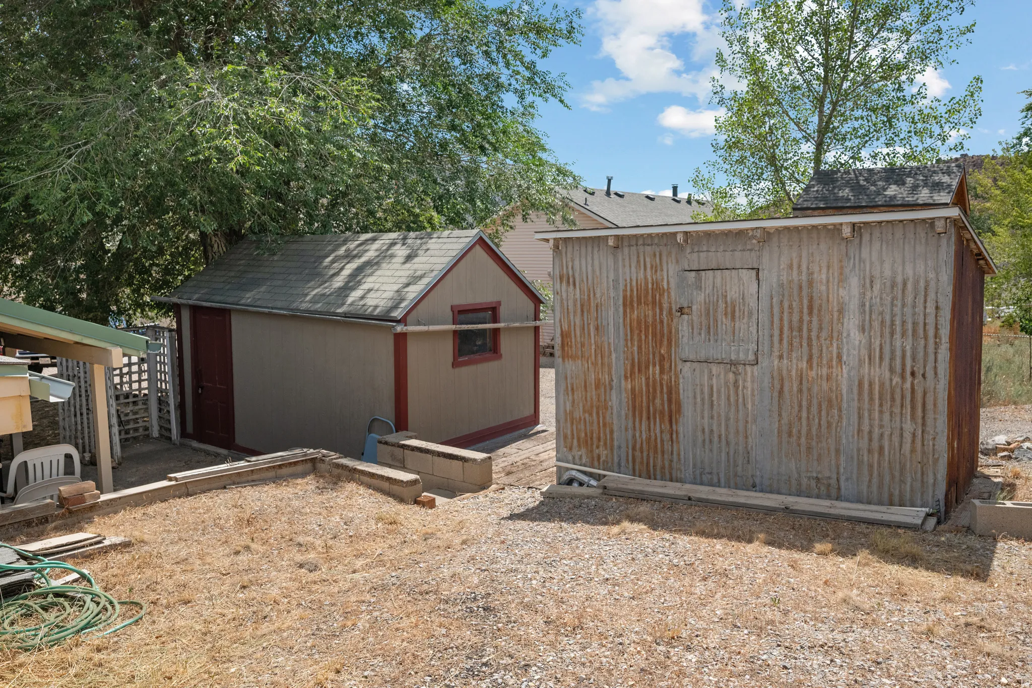 Two detached storage sheds with varied exterior finishes