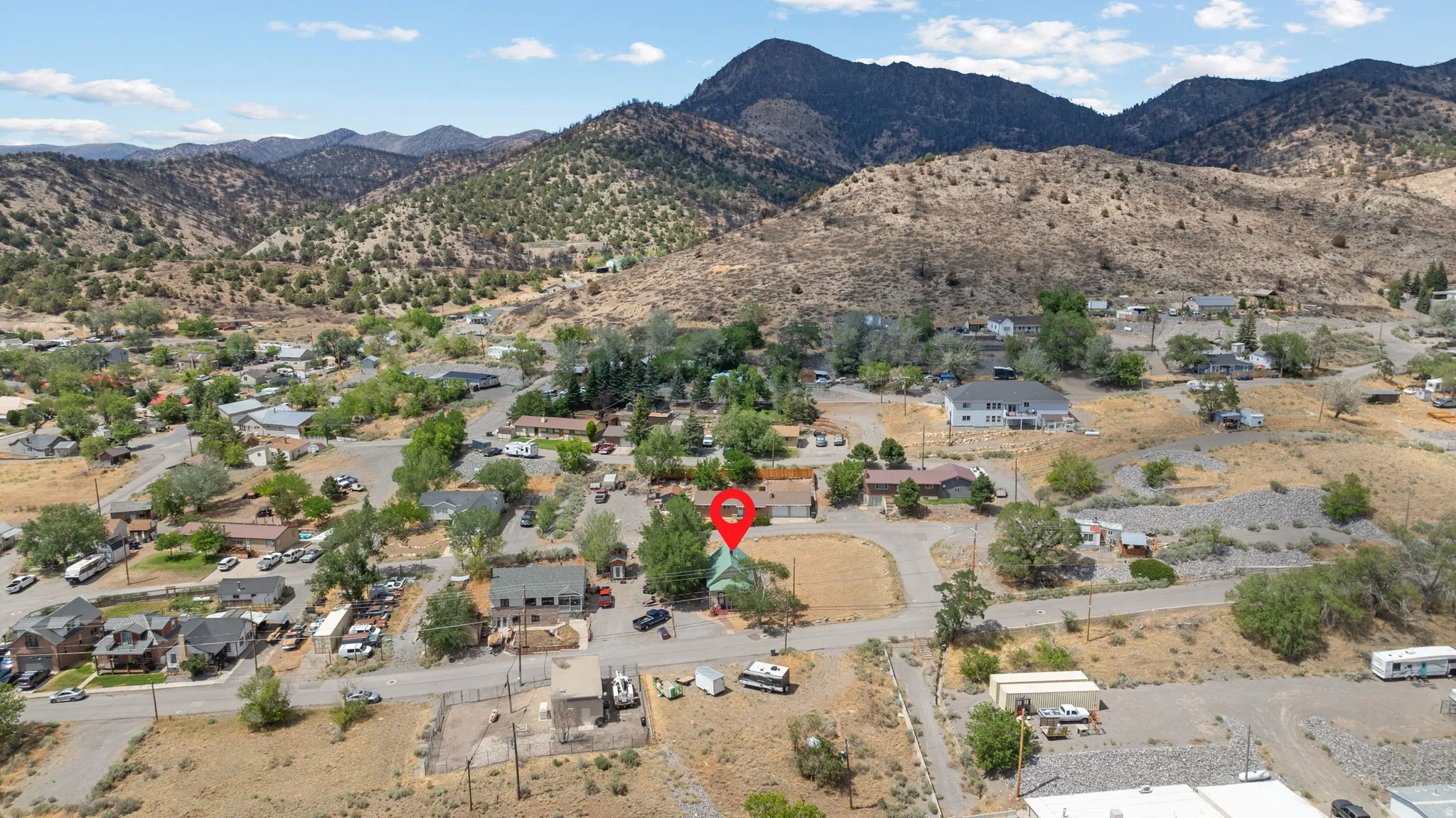 Aerial perspective showcasing a residential property surrounded by mountainous terrain