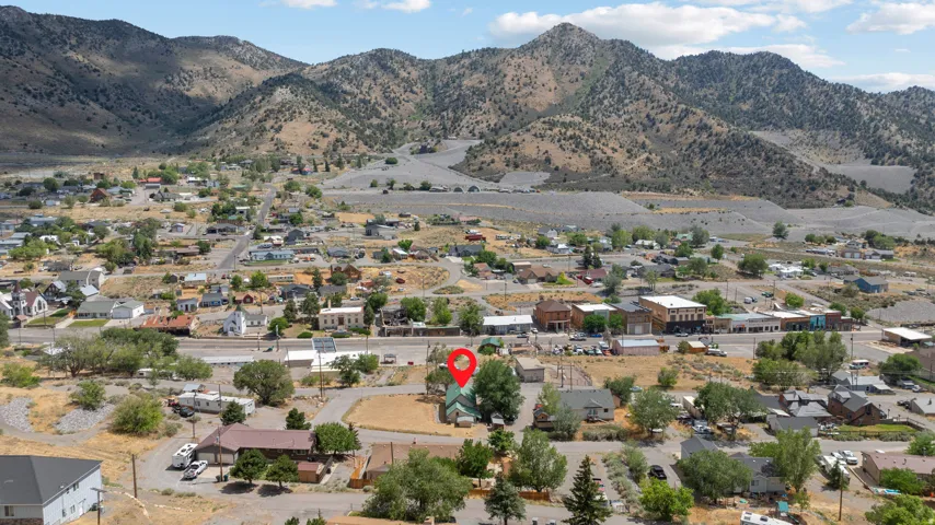 Expansive mountain backdrop framing a community with established buildings and mature trees