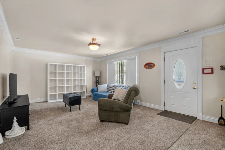 Living area featuring light-colored walls and carpet flooring