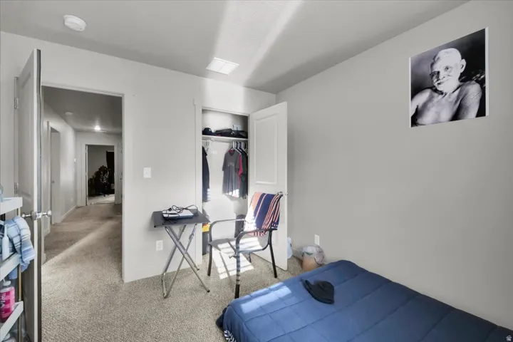 Carpeted interior room with light gray walls, an open closet, and a white ceiling with recessed lighting
