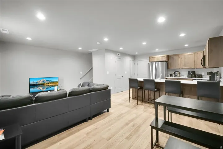 Open concept living space featuring wood-finish flooring and recessed lighting