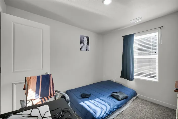 Neutral-toned room featuring a single window with blinds and dark curtains