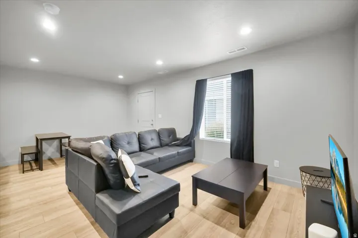 Living area featuring light wood-finish flooring and recessed lighting