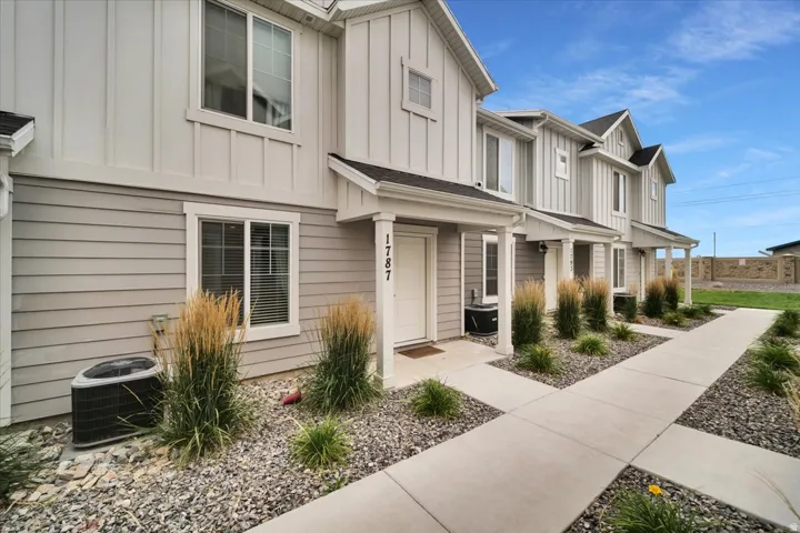 Contemporary townhome exterior featuring light gray horizontal siding and white board-and-batten accents