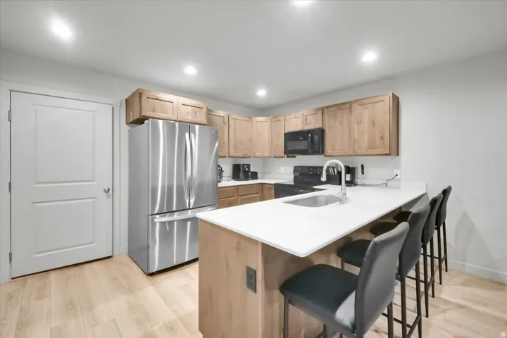Modern kitchen featuring light wood-finish flooring, recessed lighting, and light wood cabinetry