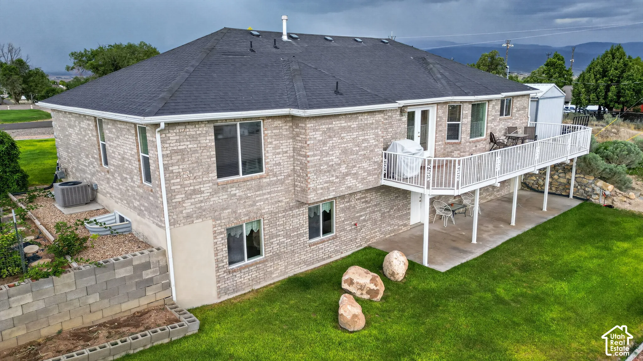 Two-story residence featuring light-toned brickwork and a dark shingle roof