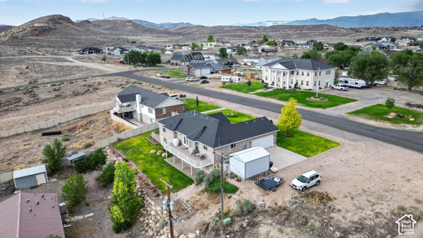 Expansive property featuring a multi-level residence with a tiered deck, attached two-car garage, and a detached metal storage shed