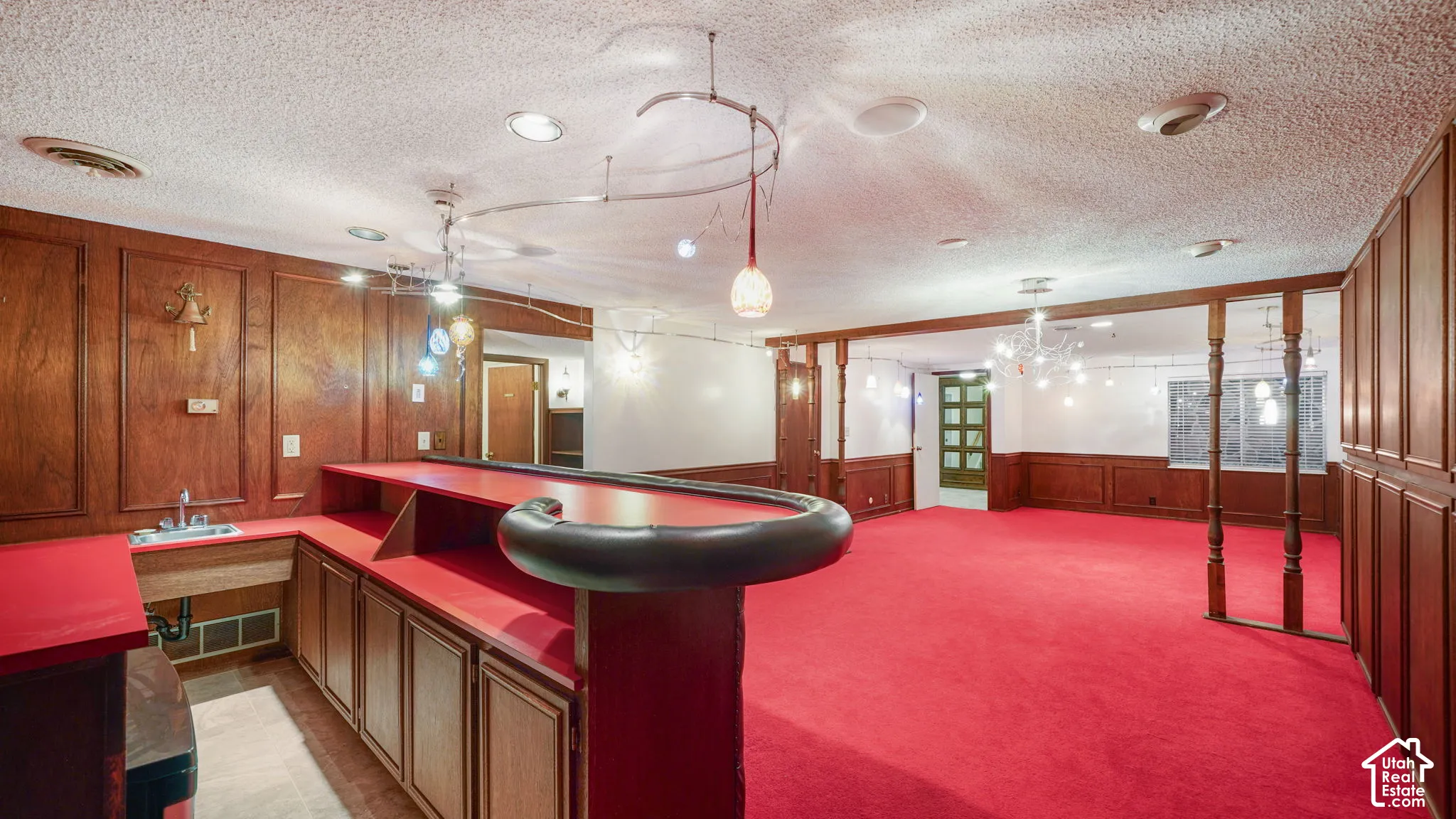Entertainment area featuring a built-in wet bar with a sink and extensive cabinetry