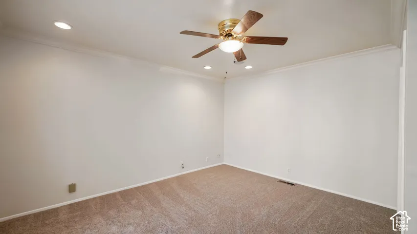 Neutral tone wall finishes with crown molding and recessed lighting