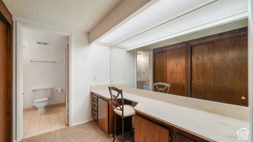 Built-in vanity with a light-toned countertop, integrated mirror, and dark wood-finish cabinetry
