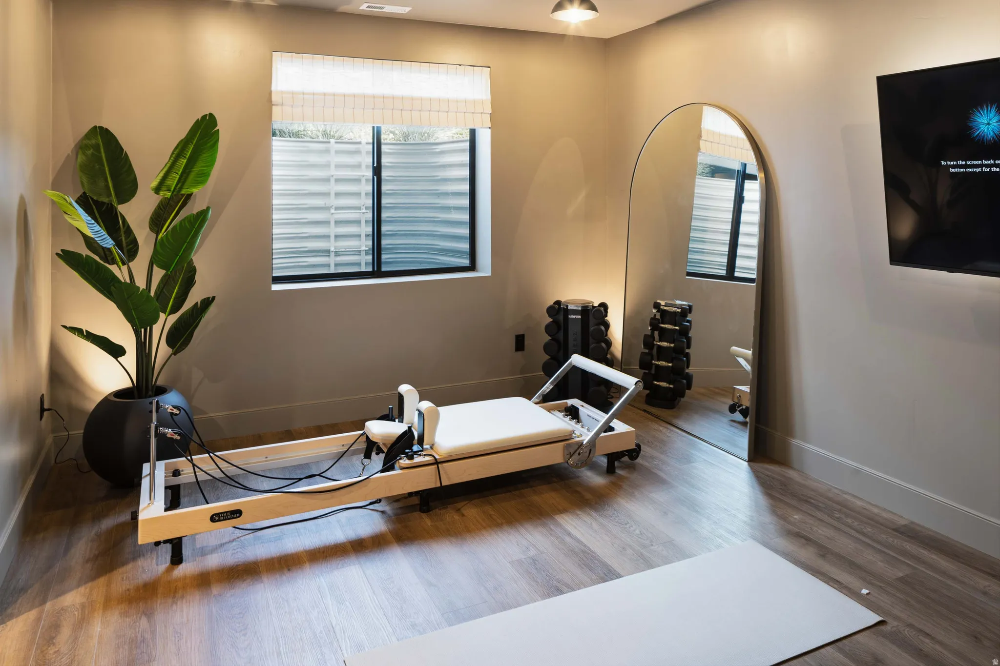 Finished space featuring wood-finish flooring, recessed lighting, and a wall-mounted media display