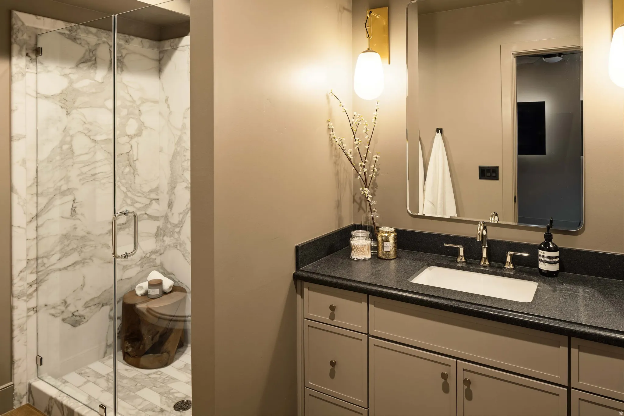 Shower with frameless glass enclosure and marble-look wall tiling