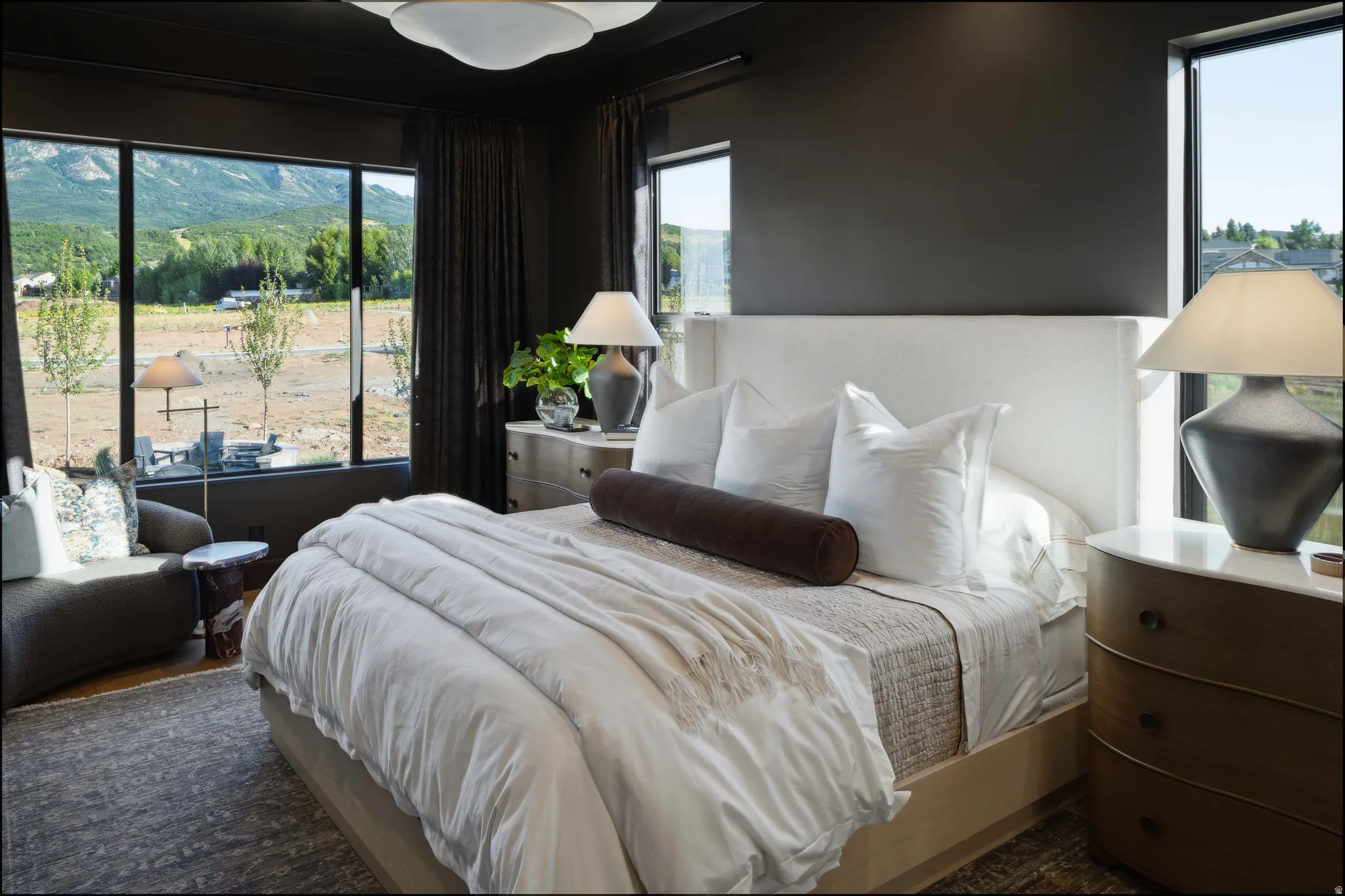 Expansive windows with mountain backdrop, dark accent wall, recessed lighting, wall-to-wall carpeting, and a built-in ceiling light fixture