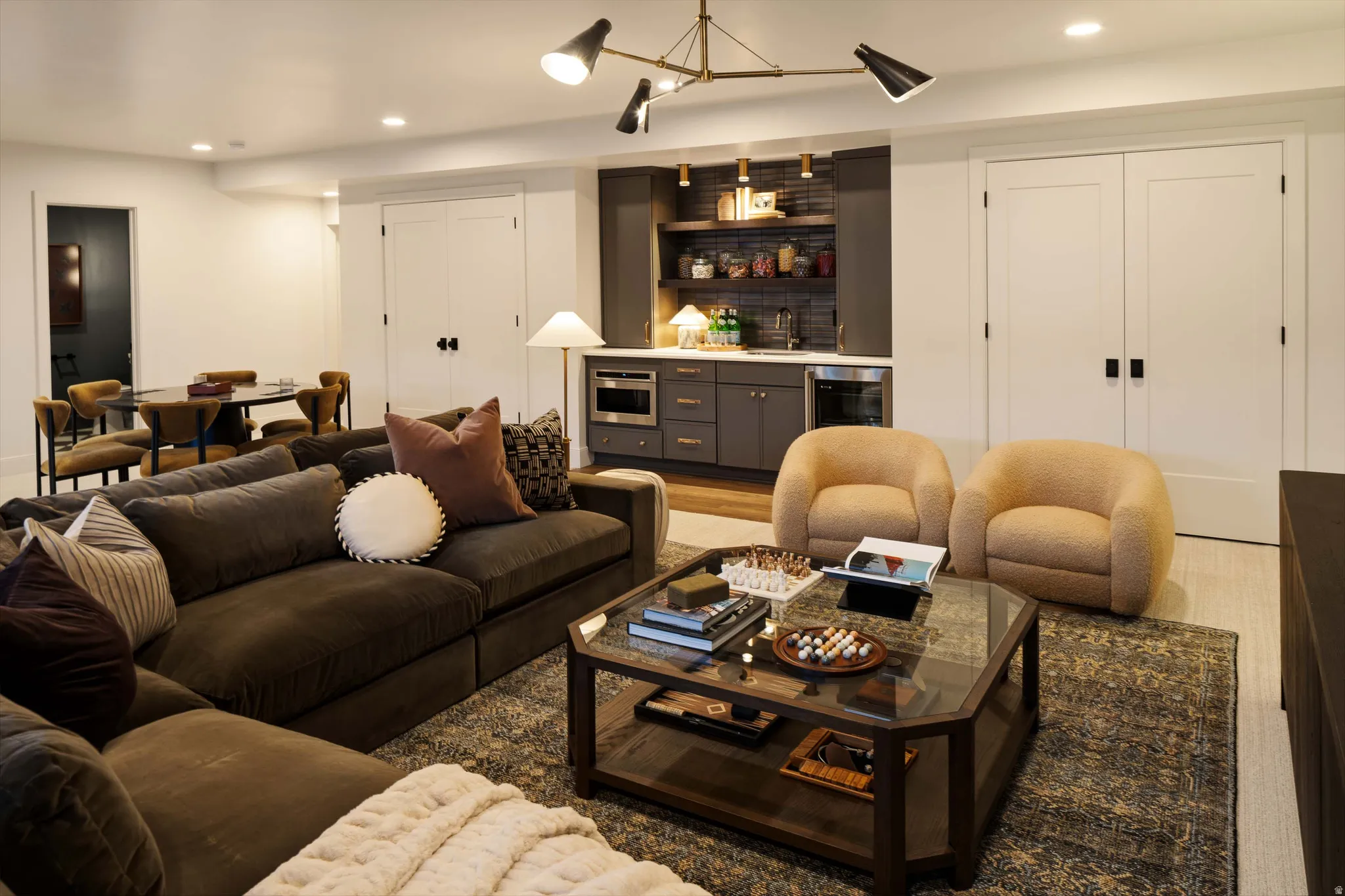 Spacious entertainment area featuring a built-in wet bar, recessed lighting, and a contemporary ceiling fixture