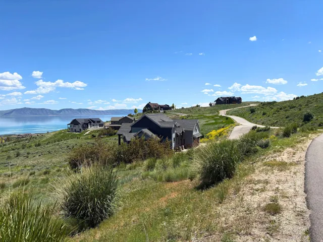 Sloped lot featuring partial water frontage and existing residential structures